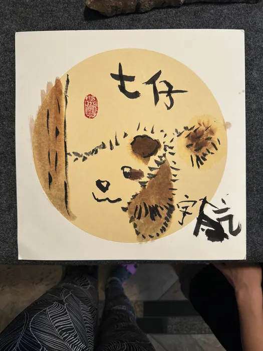 A panda painted on a round gold ground
