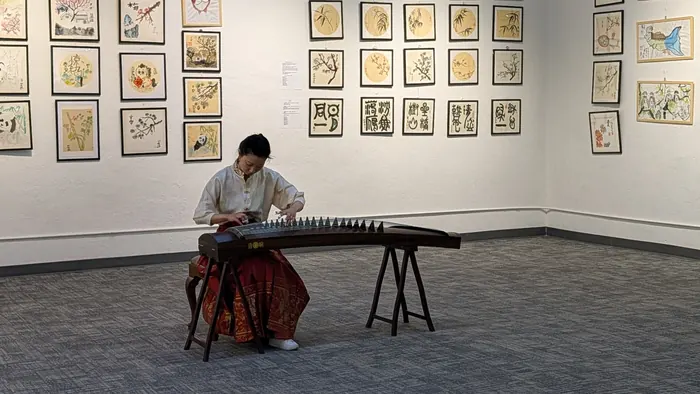 Playing the guzheng before a full room