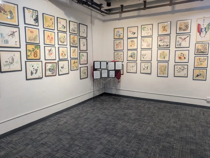 Framed paintings filling the exhibition wall