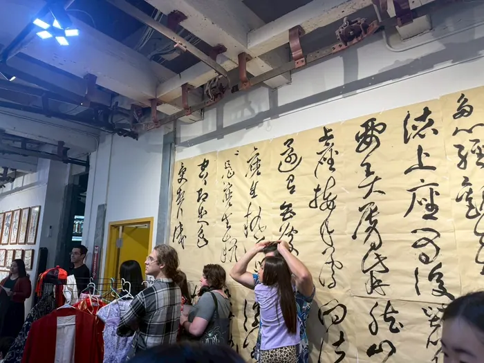 Visitors photographing the calligraphy wall