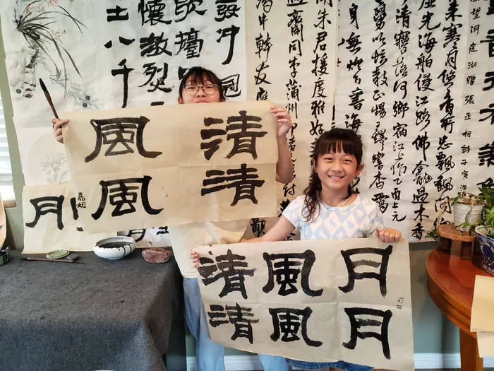 Students holding up their calligraphy
