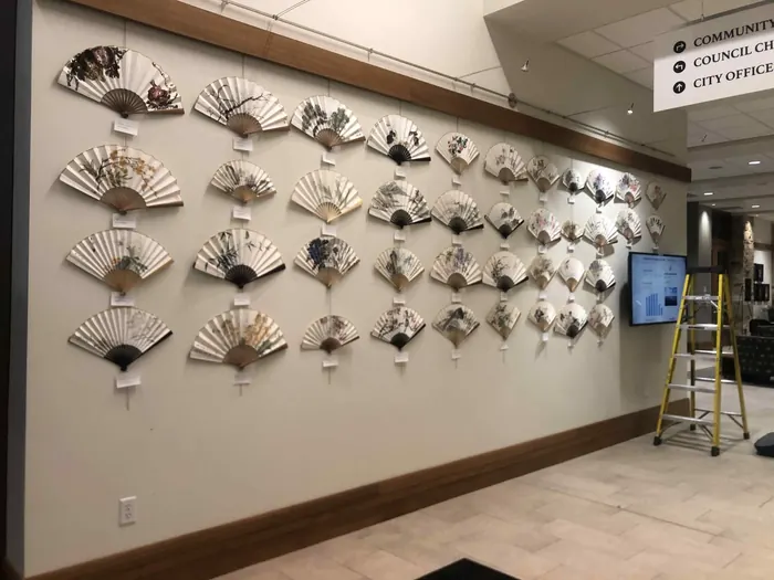 Hand-painted fans mounted along the wall