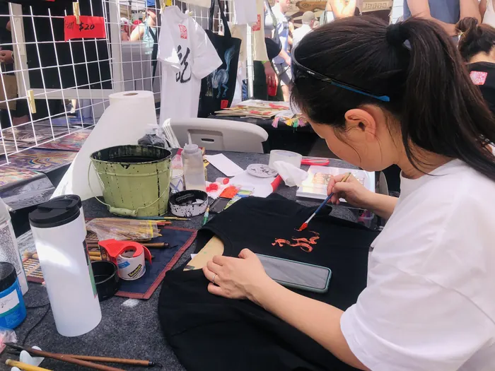 Painting a design onto a tote bag at the booth