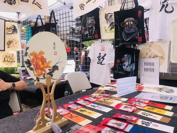 Fans, bookmarks, and ink paintings laid out for visitors