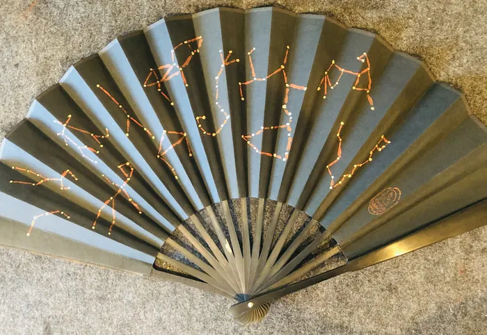 A folding fan painted with a constellation design